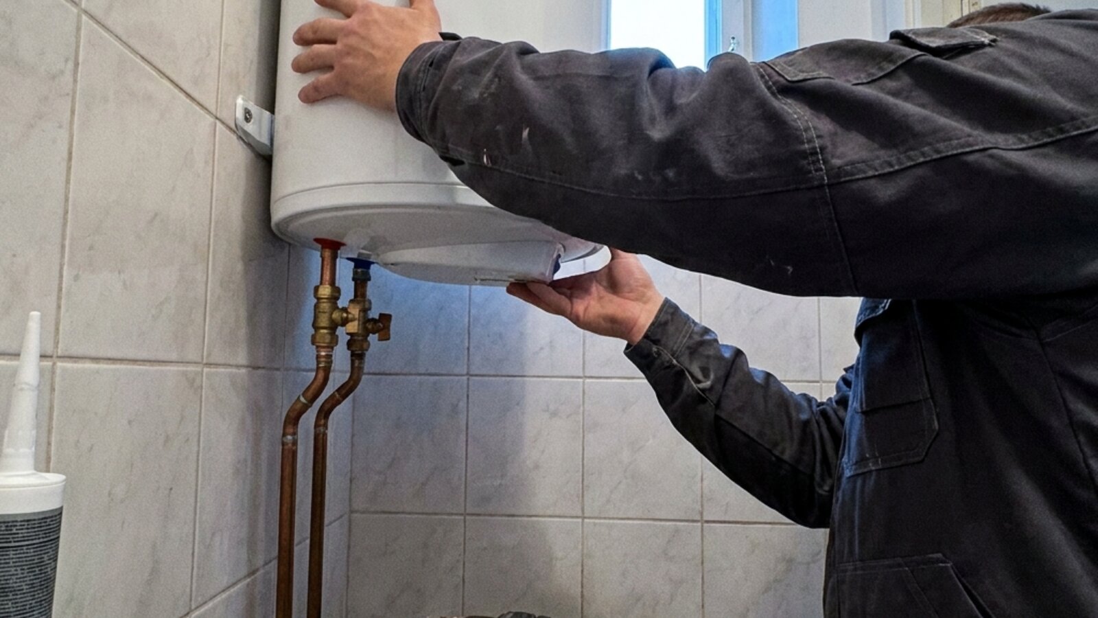 Torumees kinnitab 80-liitrist elektriboilerit Tallinna korterimaja vannitoa seinale