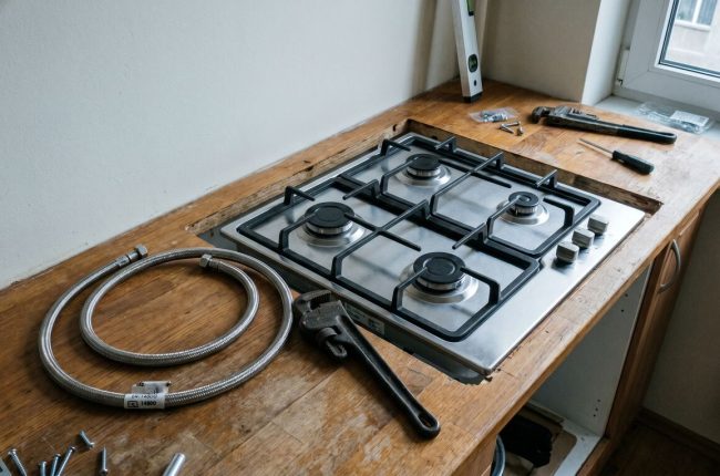 Подключение газовой плиты в Таллинне: новая плита и инструменты на кухонном столе